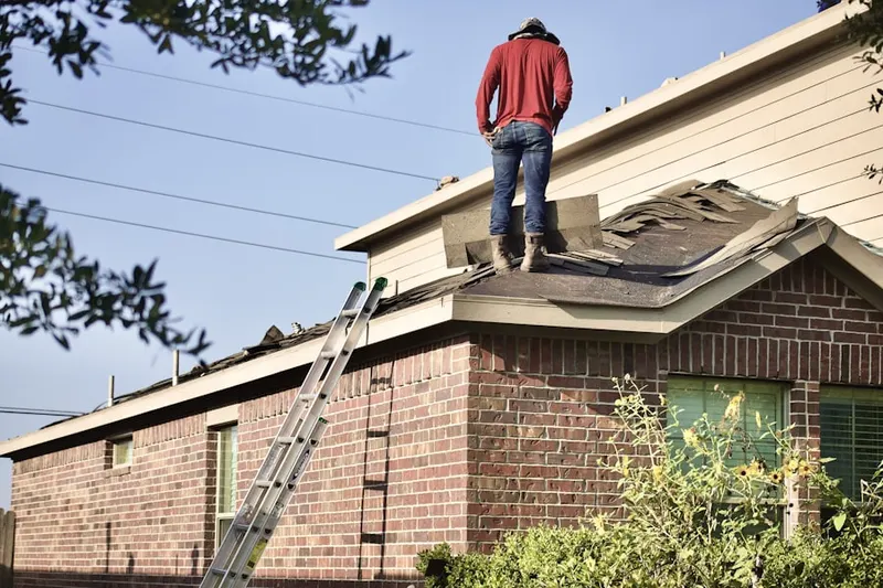 Professional roofer working on a residential roof in West Wayne